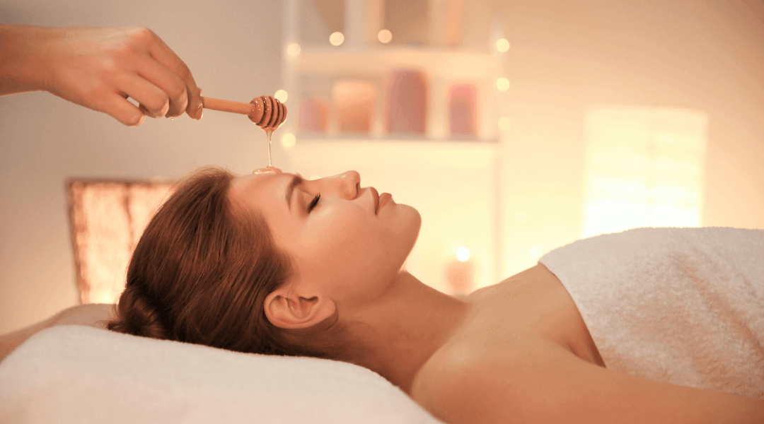 Woman lying down enjoying a Manuka Honey Face Mask skin treatment