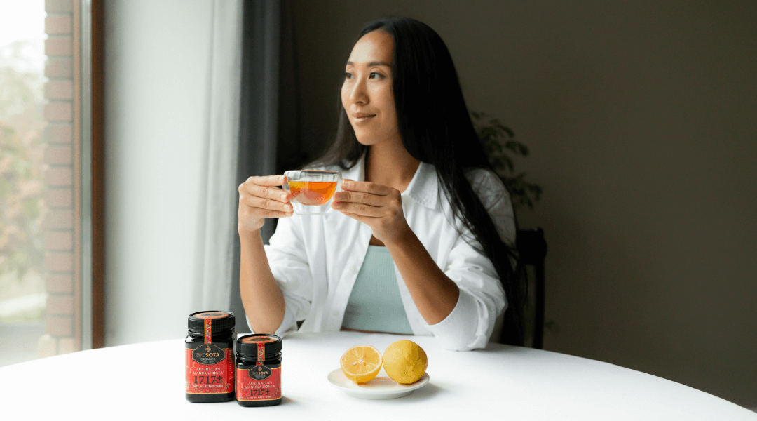 Lady enjoying cup of lemon tea with high MGO Manuka honey
